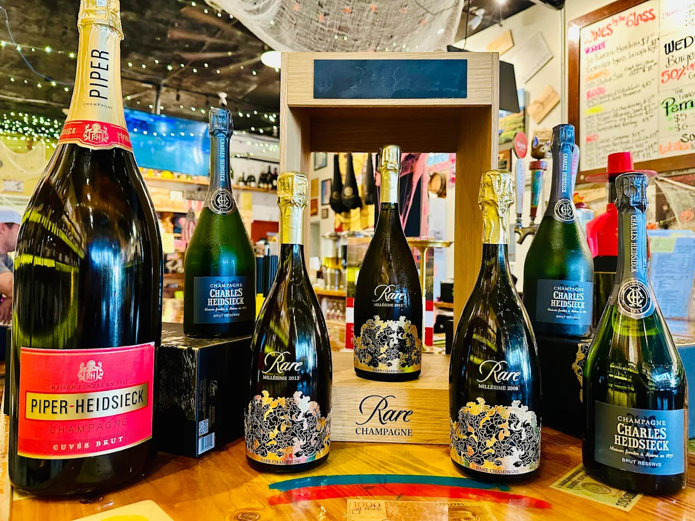 Bottles of Piper-Heidsieck champagne displayed on a wooden counter.